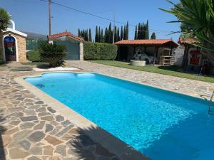 a blue swimming pool in a yard with a house at DIMIS swimming pool small villa in Eretria