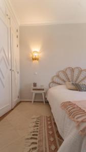um quarto com uma cama com uma luz na parede em Bella Estrela em Albufeira