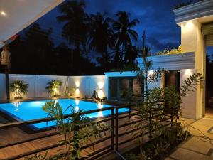 a villa with a swimming pool at night at CEYLON VILLA NILAVELI in Trincomalee