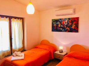 1 dormitorio con 2 camas y un cuadro en la pared en Villa Verde, en Badesi