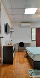a bedroom with a bed and a desk and a tv at Subsopon in Phra Nakhon Si Ayutthaya