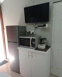 a microwave sitting on top of a counter with a tv at Atholl Heights Homee in Westville