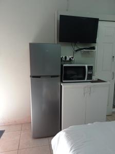 a small kitchen with a microwave and a refrigerator at Atholl Heights Homee in Westville