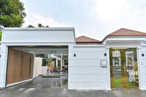 Casa blanca con garaje con puerta de madera en 4BD Pool Villa Pattaya with Jacuzzi - Exquisite Pool Villa A, en Pattaya South