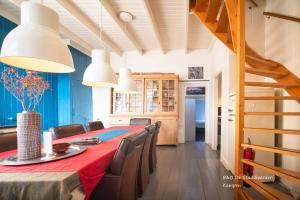 a dining room with a red table and chairs at De Stadsboerderij in Kampen