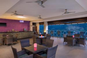 een restaurant met tafels en stoelen en een bar bij Radisson Hotel Kandy in Kandy
