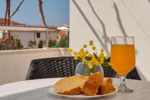a plate of bread and a glass of orange juice at House Marta in Baška Voda