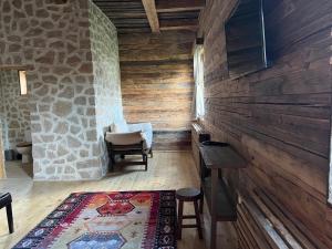 a room with a stone wall and a table and a chair at Casa Batraneasca - Domeniul Valea lupilor in Şirnea