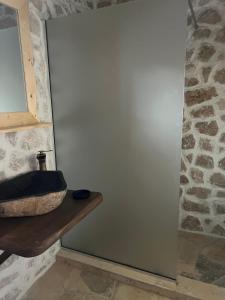 a bathroom with a sink and a stone wall at Casa Batraneasca - Domeniul Valea lupilor in Şirnea