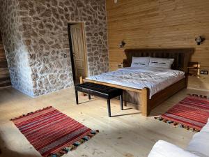 a bedroom with a bed and a stone wall at Casa Batraneasca - Domeniul Valea lupilor in Şirnea +1 photo
