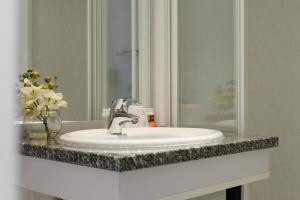a bathroom counter with a sink and a mirror at Hotel George - Astotel in Paris