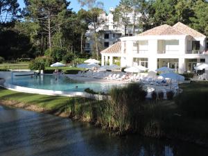 una piscina accanto a un edificio e a un fiume di Green Park - Lloret de Mar Punta del Este a Punta del Este