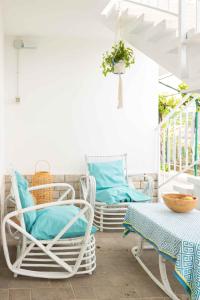 a porch with two chairs and a table and a swing at VITEDIMARE APARTMENT SABBIA - SAND in Muggia