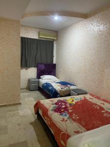 een slaapkamer met 2 bedden in een kamer bij Appartement 1er étage numéro 7 POUR FAMILLE in Marrakesh