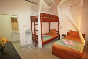 a bedroom with two bunk beds and a fan at Manta Manta Guesthouse in Labuan Bajo