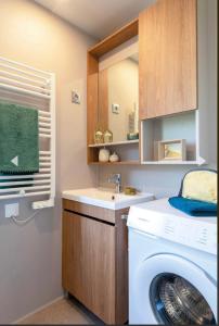 a bathroom with a washing machine and a sink at A Casa Mia Plage in Hermanville-sur-Mer