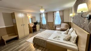 une chambre d'hôtel avec un lit et une chaise dans l'établissement Hotel Anhea, à Veliko Tarnovo