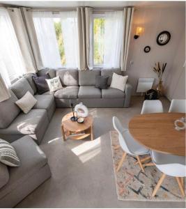 a living room with a couch and a table at A Casa Mia Plage in Hermanville-sur-Mer