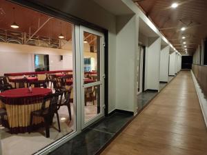un pasillo de un restaurante con mesas y sillas en CLIFFVIEW RESORT, en Yercaud