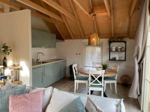 a living room with a table and a kitchen at Royal Veluwe in Putten