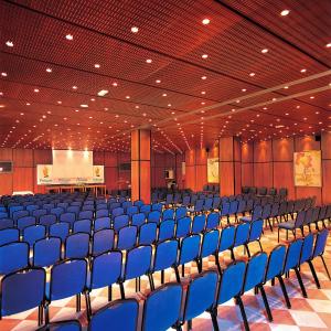 un grand auditorium avec des chaises bleues et une scène dans l'établissement Esencia de La Palma by Princess - Adults Only, à Fuencaliente de la Palma