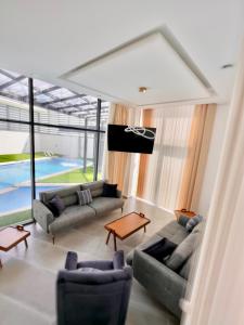 sala de estar con sofás, TV y piscina en Granada Villas en Jericho