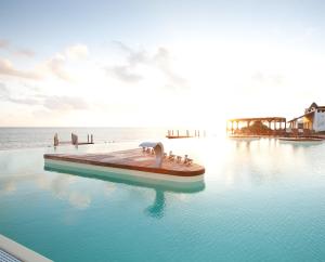 a swimming pool with a boat in the water at Essque Zalu Zanzibar in Nungwi +287 photos