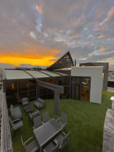 a house with a lawn with chairs and a sunset at Granada Villas in Jericho