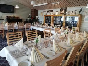 un comedor con mesas y sillas blancas en Bardufosstun, en Bardufoss