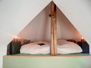 Ce lit se trouve dans un dortoir doté d'un plafond triangulaire. dans l'établissement Ô Petit Château, à La-Roche-en-Ardenne