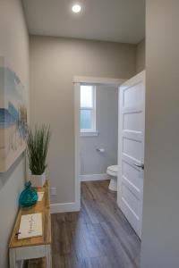 a bathroom with a toilet and a table and a door at The Jetty House in Ocean Shores +32 photos
