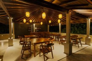 a restaurant with wooden tables and chairs and lights at Kiss Blossom in Mirissa