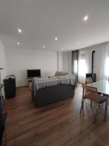 a bedroom with a bed and a table and a television at APARTAMENTO ANCHA CENTRO in Huétor-Tájar +22 photos