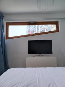 a bedroom with a flat screen tv and a bed at Fenestrelle By LGM une chambre, climatisation, wifi in La Grande-Motte