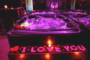 a jacuzzi tub with a sign that says i love you at Suite Romantique Jacuzzi & Sauna privé Full options TV in Perpignan