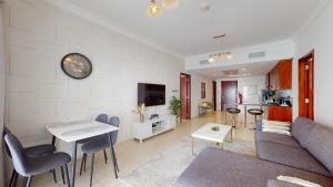 ein Wohnzimmer mit einem Sofa und einem Tisch in der Unterkunft LV38 - Elegant 2BHK in Lake View Tower in Dubai