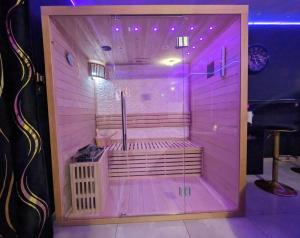 - un sauna avec éclairage violet dans une pièce dans l'établissement Suite Romantique Jacuzzi & Sauna privé Full options TV, à Perpignan
