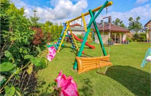 a playground in a yard with colorful swings at Nice Home In Grzybowo With Wifi And 2 Bedrooms in Grzybowo
