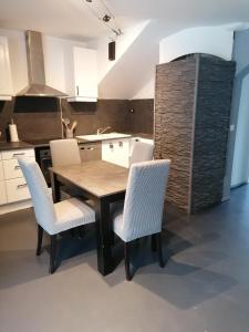 - une cuisine avec une table en bois et des chaises blanches dans l'établissement VILLA TERRE NEUVE, à Signes