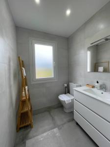 baño con lavabo y aseo y ventana en Gure Urdaibai by Urdaibai Rentals, en Altamira