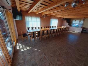 a dining room with a long table and chairs at Kukoriškių sodyba in Kukoriškiai