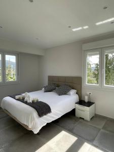 Schlafzimmer mit einem großen weißen Bett und Fenstern in der Unterkunft Gure Urdaibai by Urdaibai Rentals in Altamira
