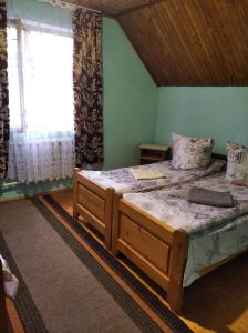 a bedroom with two beds and a window at Радуга in Podobovets