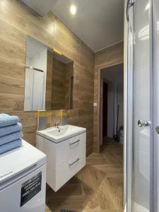 W łazience znajduje się biała umywalka i lustro. w obiekcie Apartament KaMaRo w Słubicach