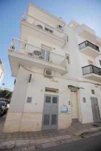een wit gebouw met een balkon en twee deuren bij Io, te e il mare in Polignano a Mare
