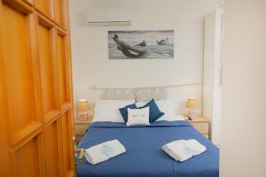 a bedroom with a blue bed with two towels on it at Io, te e il mare in Polignano a Mare