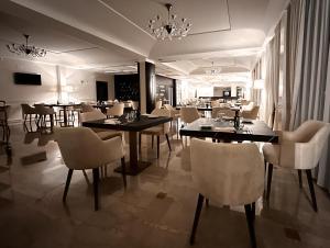 Magic Hotel في اتينا لوكانا: غرفة طعام مع طاولات وكراسي في مطعم