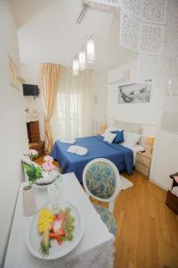 1 dormitorio con 1 cama y 1 mesa con plato de comida en Io, te e il mare, en Polignano a Mare