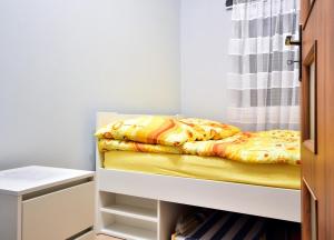 a bunk bed in a small room with a curtain at DOMKI NA TURYSTYCZNEJ in Dąbki