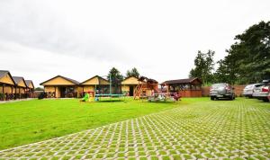 un parque con un grupo de casas y un parque infantil en DOMKI NA TURYSTYCZNEJ en Dąbki